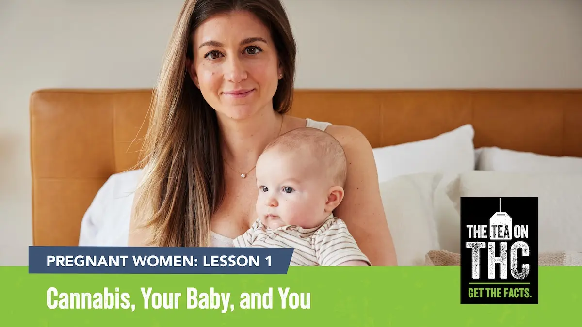 Woman and her baby sitting on a bed facing the camera with white pillows behind them